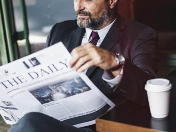 Executive reading a newspaper with coffee