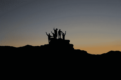 Silhouette of hikers in the sunset to demonstrate teamwork