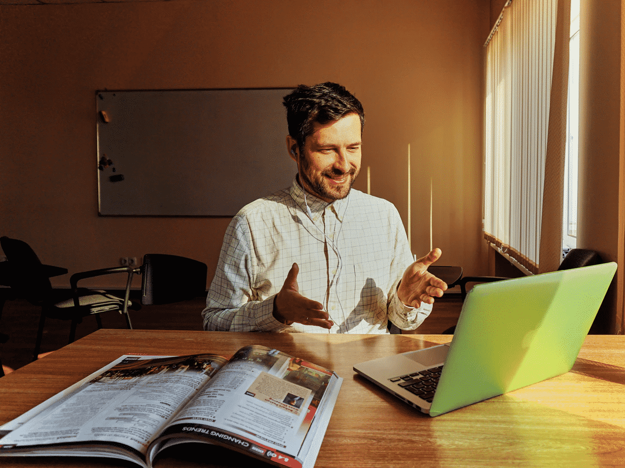 Man at desk with laptop and brochure