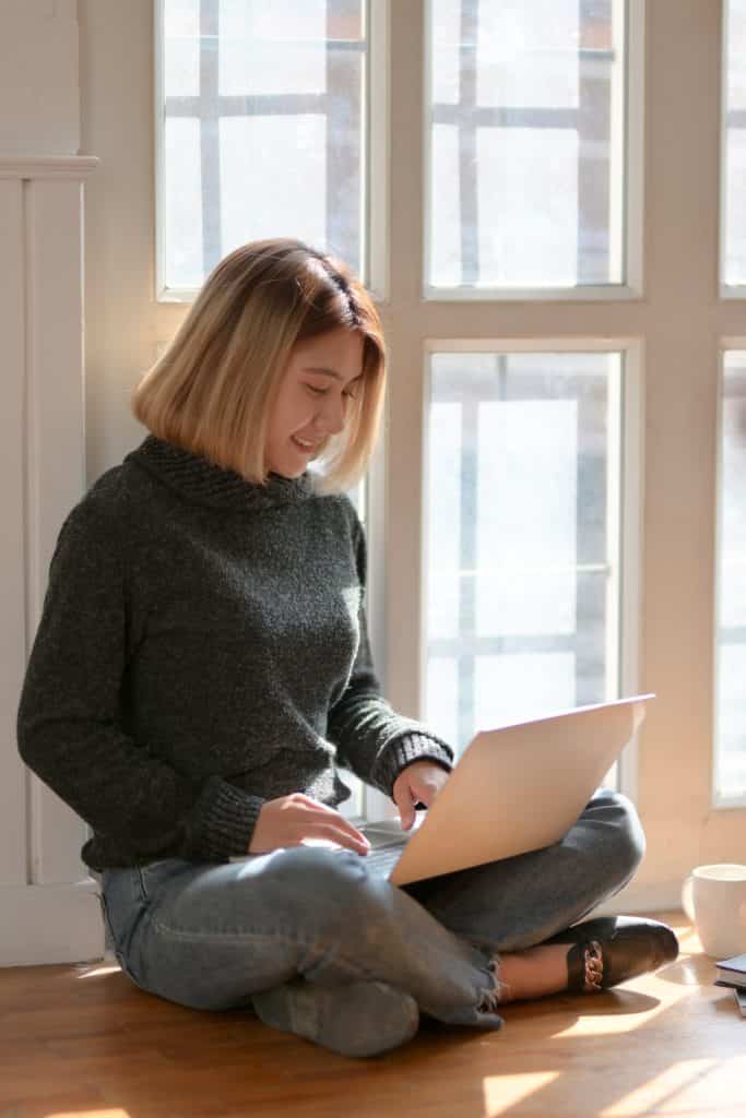 A woman composes an email on her laptop