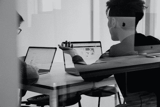 Two people with laptops in meeting