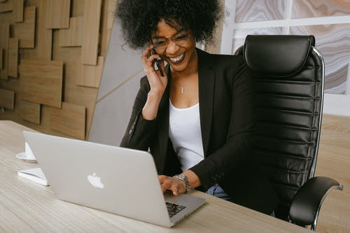 Woman working and smiling at computer screen